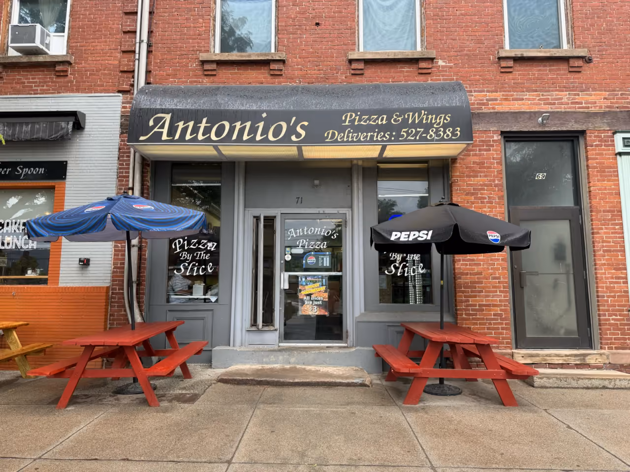 Antonio's Pizza storefront at 71 Main Street, Easthampton, with red picnic tables and umbrellas