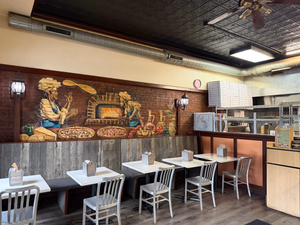 Antonio's Easthampton dining room with the pizzaiolo brick-oven mural and marble tables